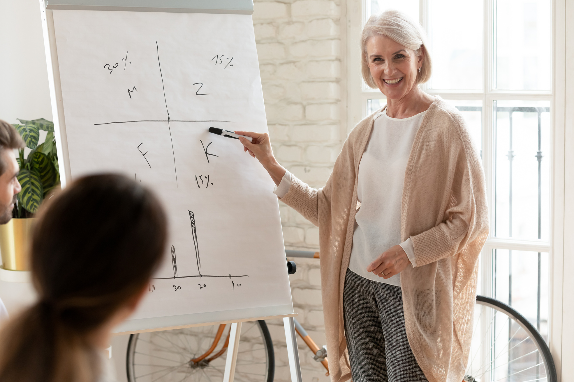 Senior Woman Presenting in Front of Colleagues